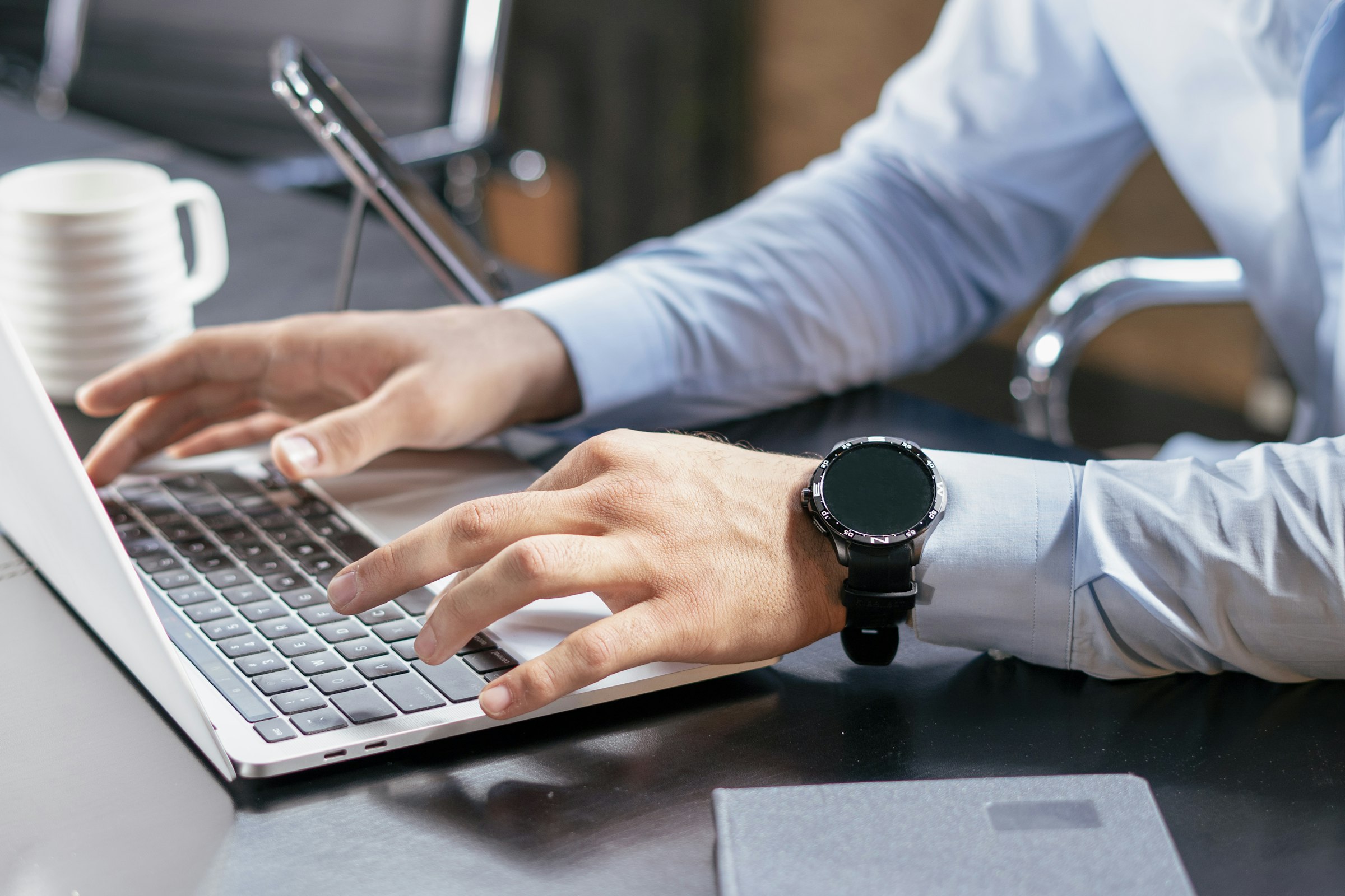 Professional typing a written follow-up on a laptop