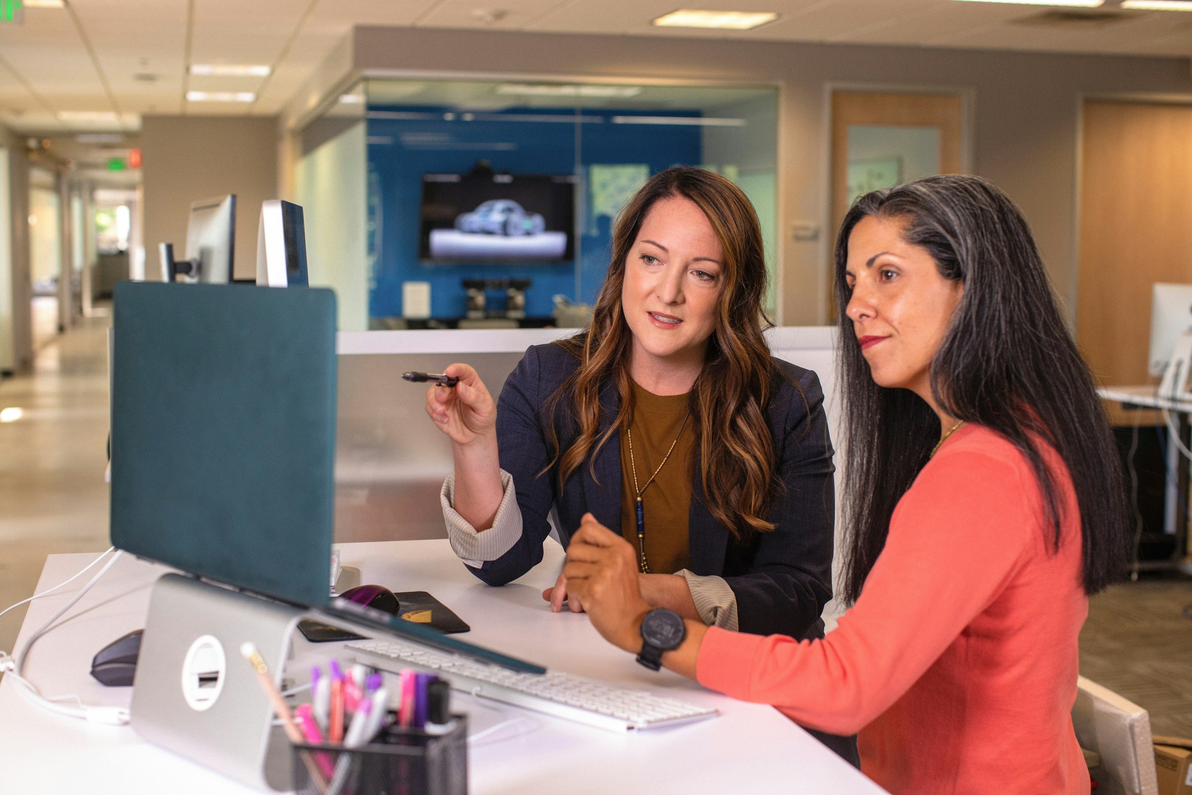 Colleagues discussing product marketing at a laptop
