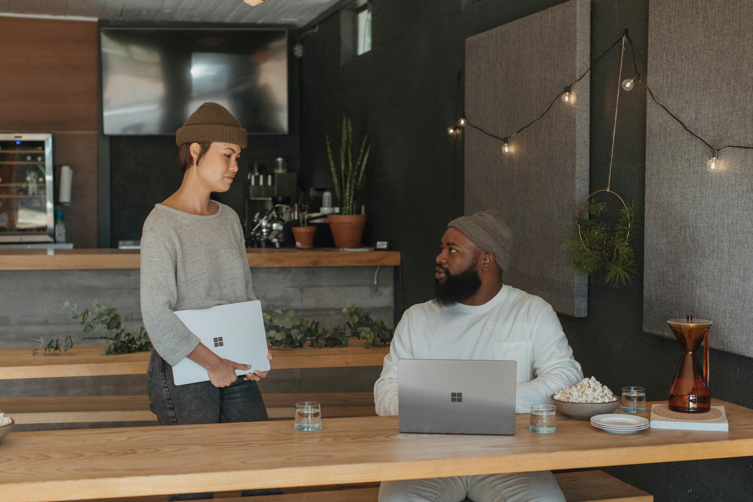 Two coworkers discussing work with laptops