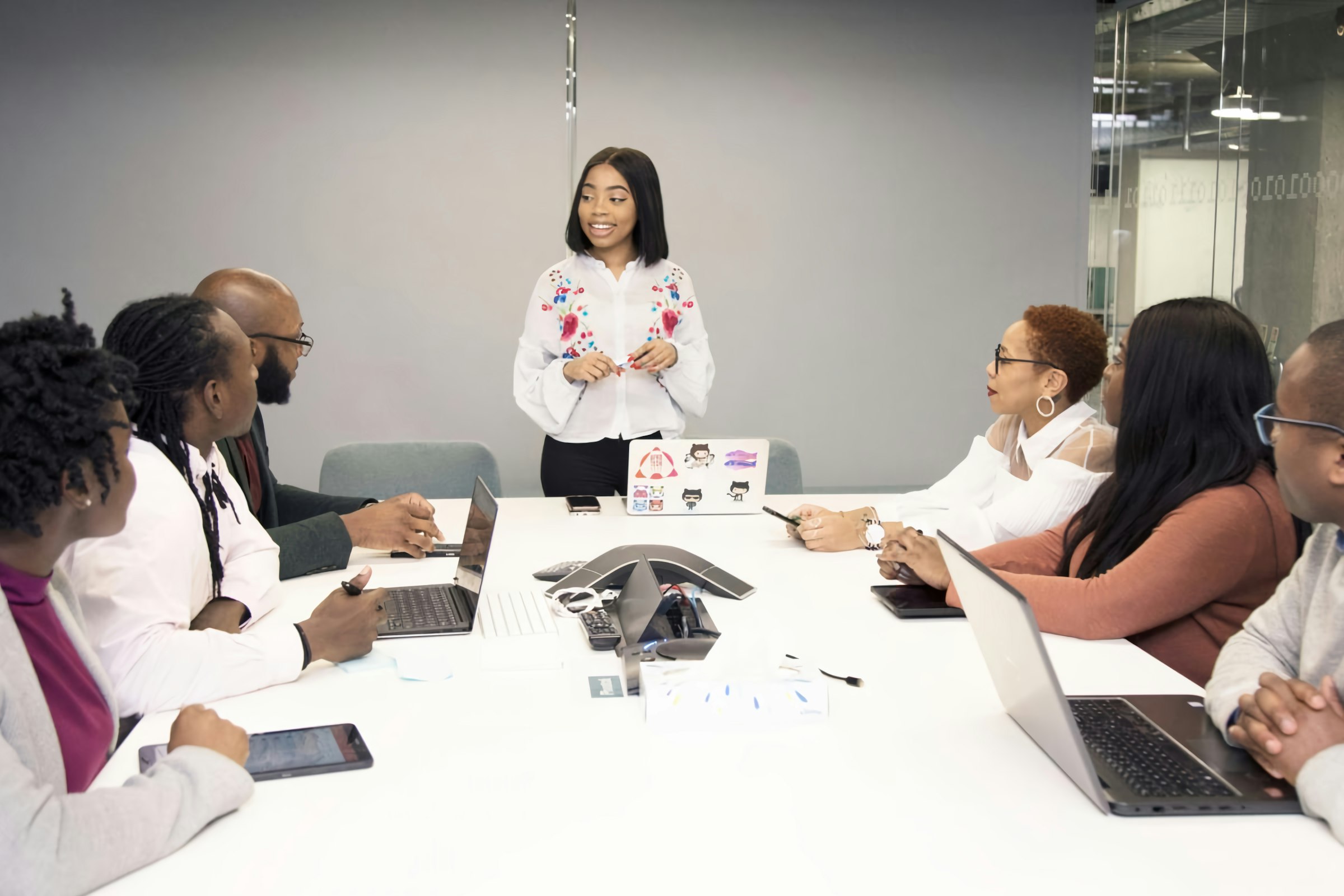 Team members listening to a colleague during a meeting around a conference table